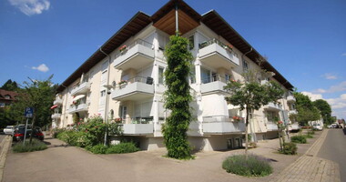 Barriere­freie Apparte­ments mit grünen Bäumen und Büschen davor